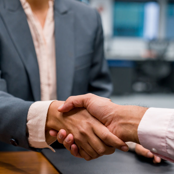 two individuals in suits shaking hands