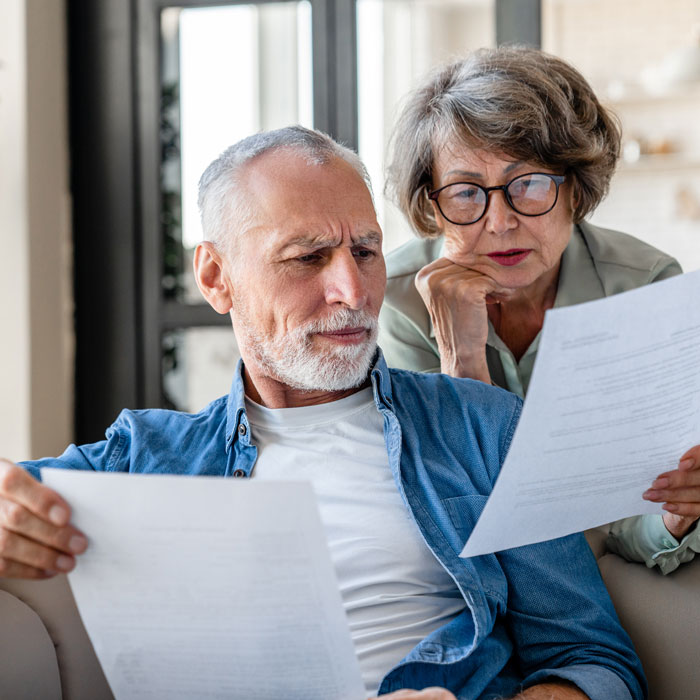 Florida senior couple looking at various documents slightly confused