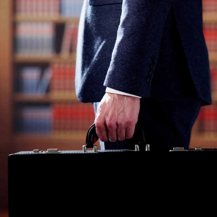 closeup of man in suit holding brief case