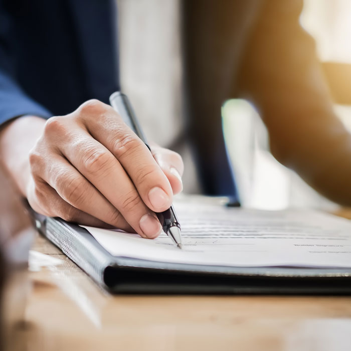 lawyer with pen pointing at signature portion of a document